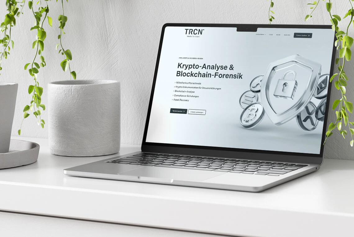 Mockup eines Laptops auf einem weißen Schreibtisch mit Pflanzen und der Startseite der Trcn-Website